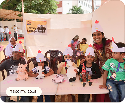 Children wearing paper hats with handmade animal puppets at the Texcity Lounge, 2018